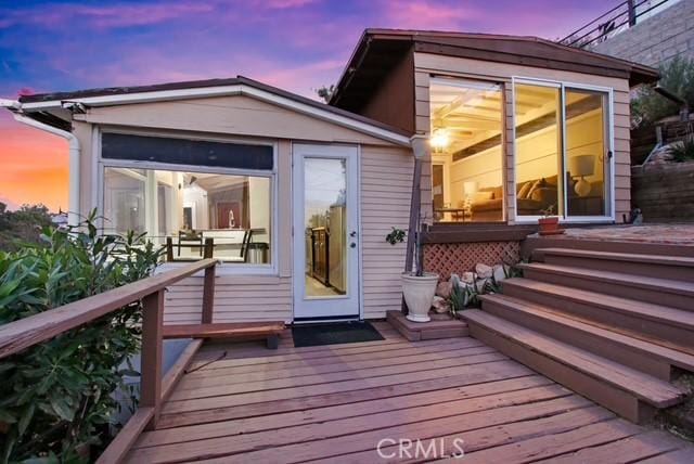 rear view of house with a wooden deck and a sunroom