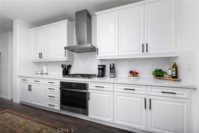 16015 Almond Ave, Chino, CA 91708 - kitchen featuring dark wood-style flooring, wall chimney exhaust hood, white cabinetry, light countertops, and appliances with stainless steel finishes