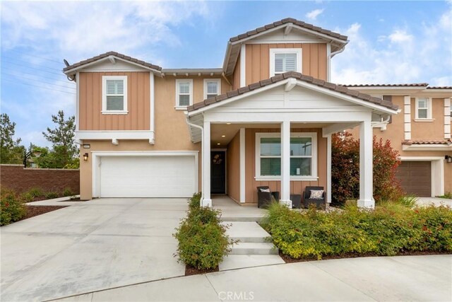 16015 Almond Ave, Chino, CA 91708 - view of front facade with driveway, board and batten siding, a porch, and a garage