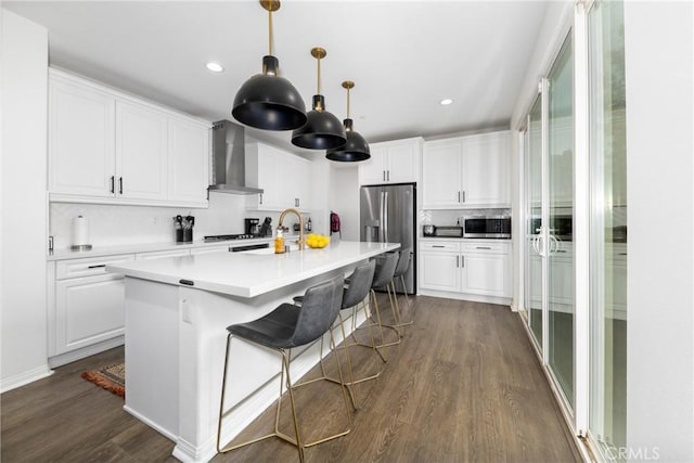16015 Almond Ave, Chino, CA 91708 - kitchen featuring white cabinetry, a sink, appliances with stainless steel finishes, dark wood-style flooring, and wall chimney exhaust hood