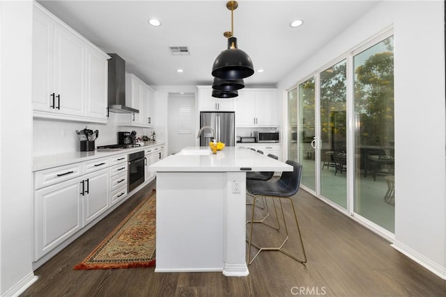 16015 Almond Ave, Chino, CA 91708 - kitchen featuring wall chimney exhaust hood, visible vents, appliances with stainless steel finishes, and dark wood-type flooring