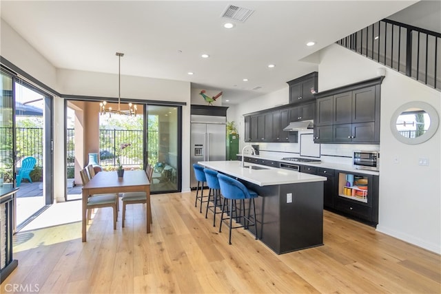 kitchen featuring light wood-style floors, visible vents, appliances with stainless steel finishes, and under cabinet range hood