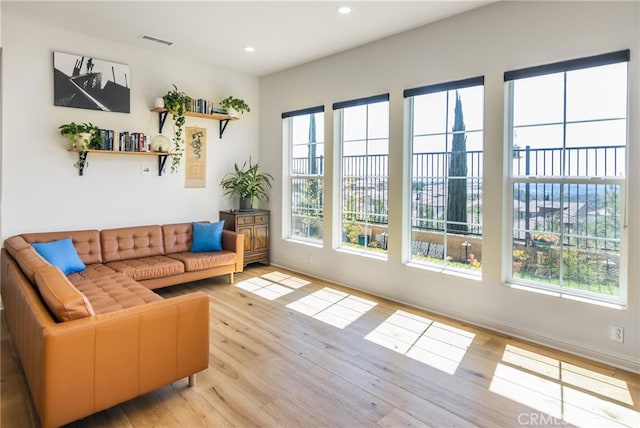 living area featuring light wood-type flooring, visible vents, and plenty of natural light