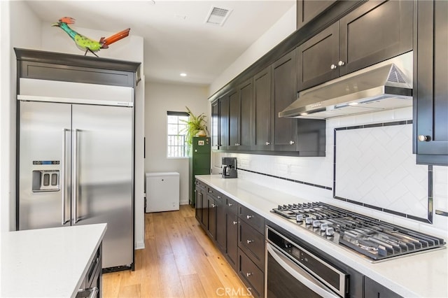 kitchen with light countertops, under cabinet range hood, visible vents, and stainless steel appliances