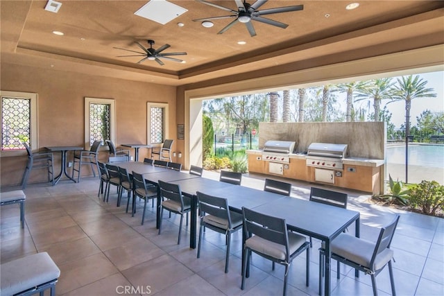 view of patio featuring grilling area, outdoor dining space, an outdoor kitchen, and ceiling fan