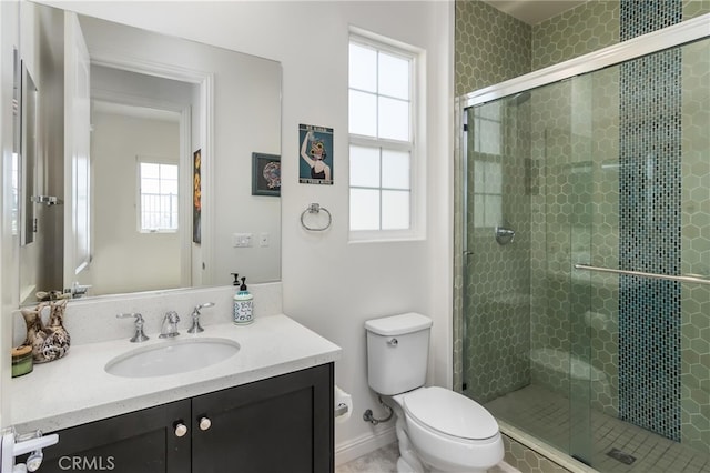 full bath with baseboards, a shower stall, toilet, and vanity
