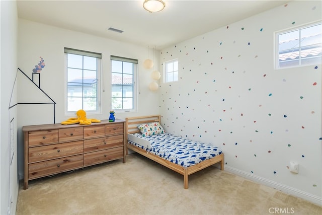 bedroom with light carpet, visible vents, and baseboards