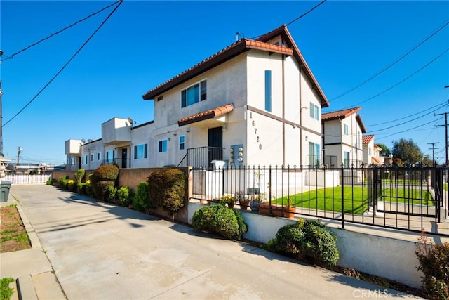 16720 S Dalton Ave, Gardena, CA 90247 - view of home's exterior with a tiled roof, stucco siding, a residential view, and a fenced front yard