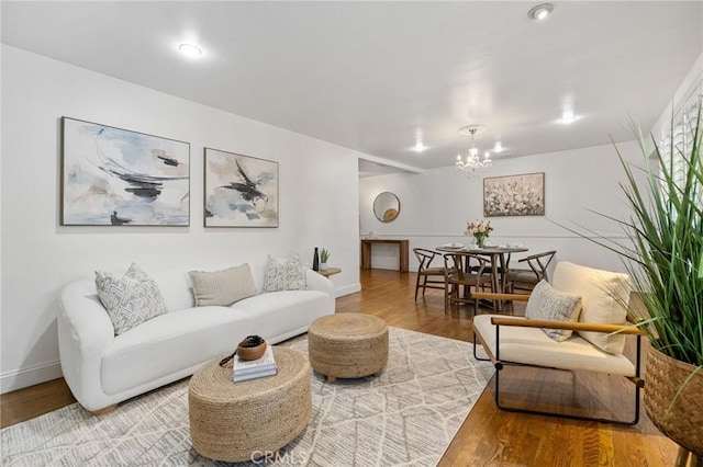 living room with a notable chandelier, baseboards, and wood finished floors