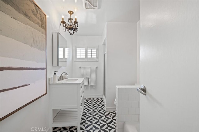 bathroom with an inviting chandelier, vanity, visible vents, a stall shower, and tile patterned floors