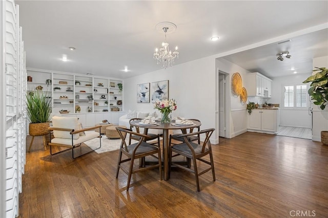 dining area featuring an inviting chandelier and dark wood finished floors