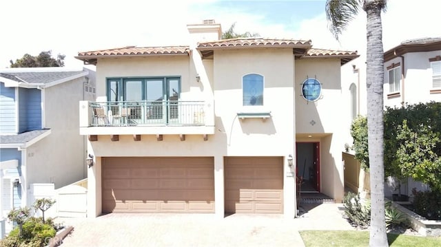 mediterranean / spanish home with an attached garage, driveway, and stucco siding