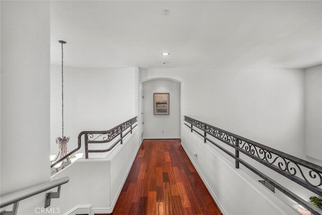 corridor with recessed lighting, arched walkways, and dark wood-style floors