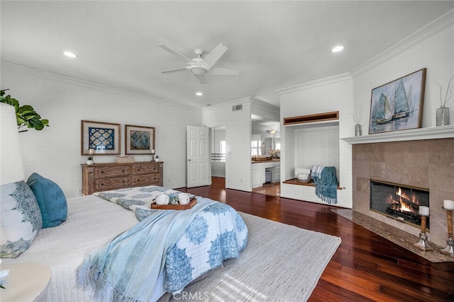bedroom featuring visible vents, ornamental molding, a fireplace, recessed lighting, and wood finished floors