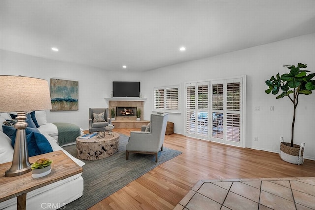 living room featuring recessed lighting, baseboards, wood finished floors, and a premium fireplace