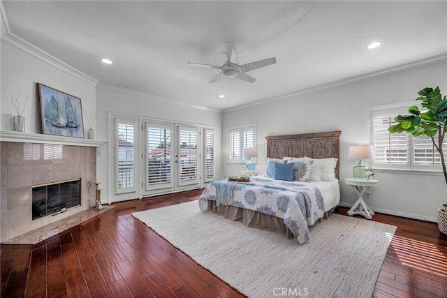 bedroom with crown molding, access to exterior, a tile fireplace, and hardwood / wood-style flooring