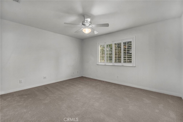 carpeted empty room featuring baseboards and ceiling fan