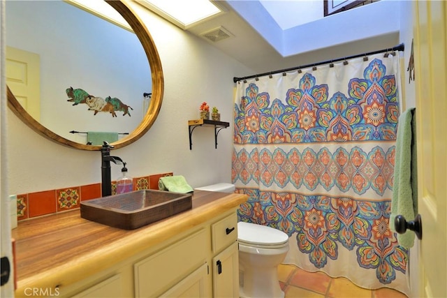 full bathroom with toilet, a shower with shower curtain, a skylight, visible vents, and vanity