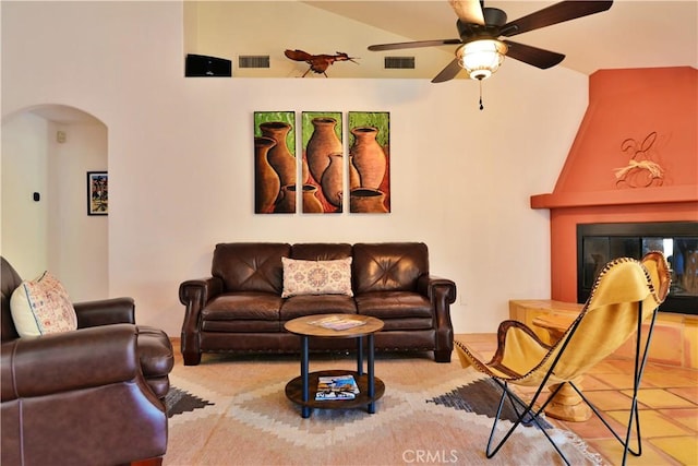 living room with visible vents, lofted ceiling, a ceiling fan, and arched walkways