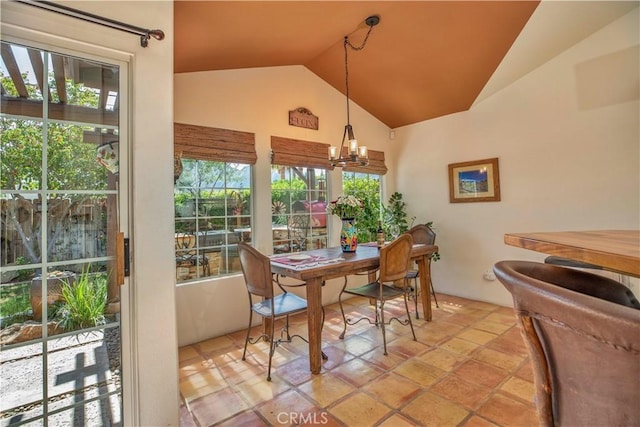 dining area featuring a healthy amount of sunlight, a chandelier, and vaulted ceiling