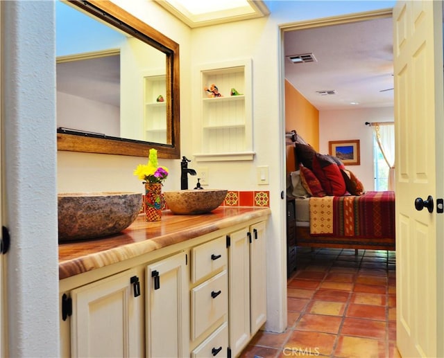 bathroom with vanity, ensuite bathroom, visible vents, and built in features