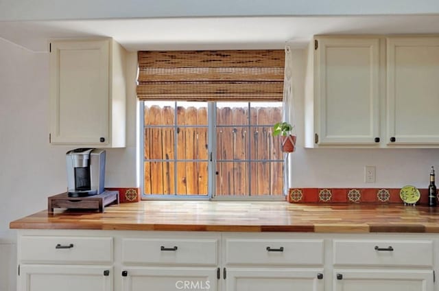 kitchen with white cabinetry and wooden counters