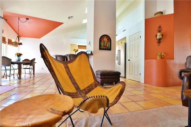 living area with an inviting chandelier, a wealth of natural light, visible vents, and tile patterned floors