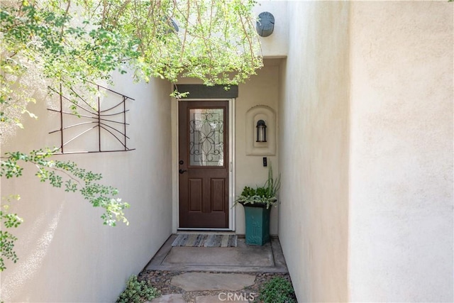 entrance to property featuring stucco siding
