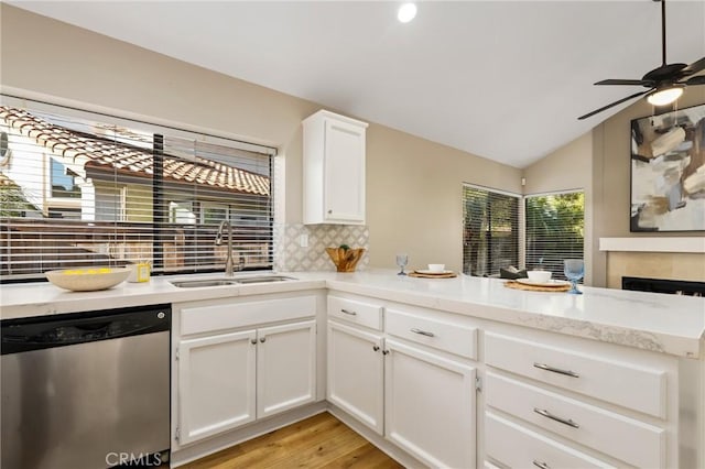 kitchen featuring tasteful backsplash, a peninsula, ceiling fan, dishwasher, and a sink