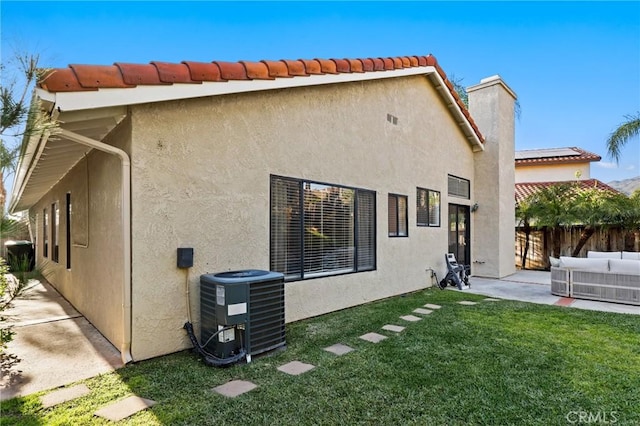 back of house featuring central air condition unit, a yard, a patio area, fence, and stucco siding