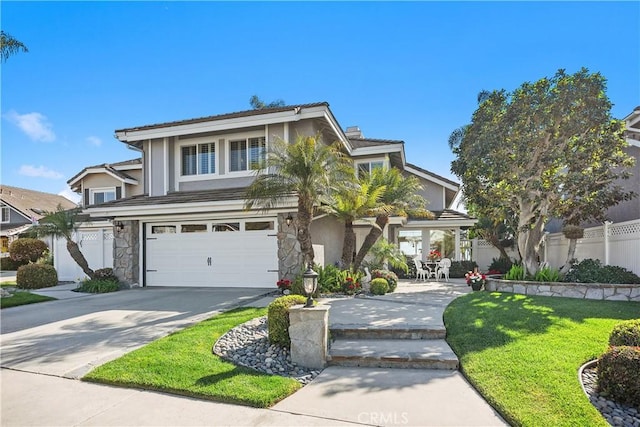traditional-style home featuring a front lawn, driveway, stone siding, fence, and a garage