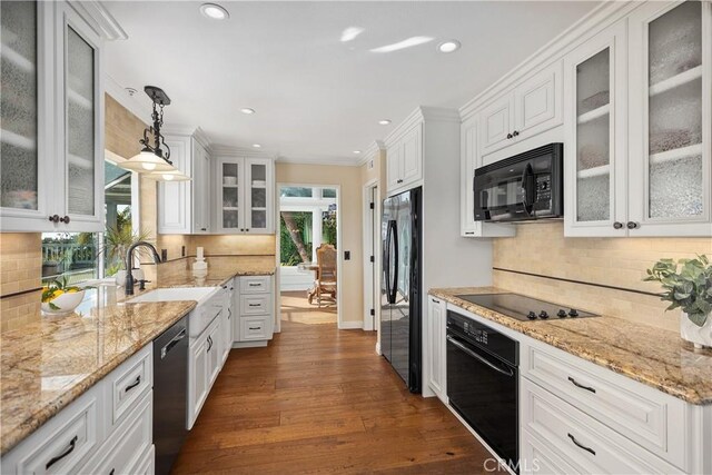 kitchen with white cabinetry, black appliances, and tasteful backsplash