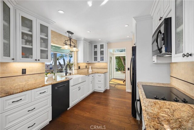 kitchen featuring decorative backsplash, a sink, black appliances, and a healthy amount of sunlight