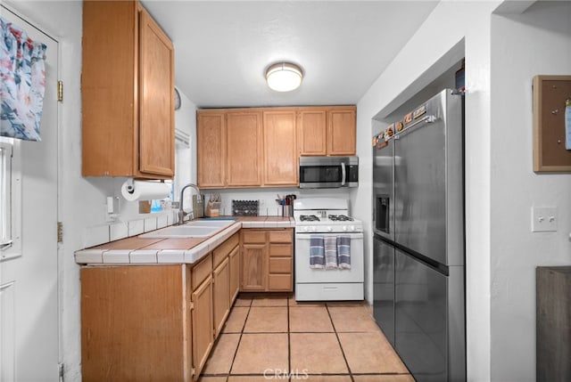 23755 Goetz Dr, Menifee, CA 92587 - kitchen featuring a sink, tile counters, light tile patterned floors, and stainless steel appliances