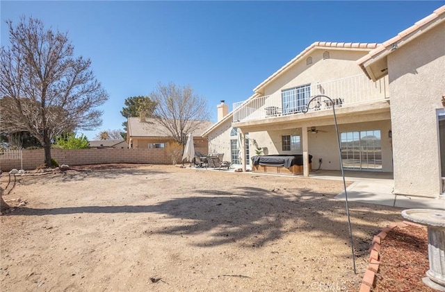 back of property featuring a fenced backyard, stucco siding, a ceiling fan, a patio, and a balcony