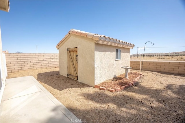 view of outdoor structure with an outbuilding and a fenced backyard