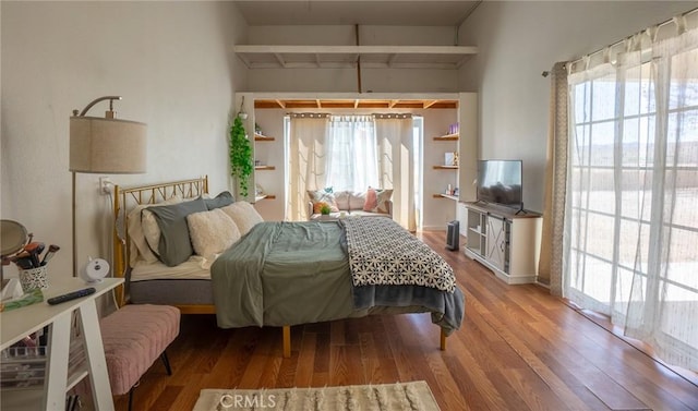 bedroom featuring wood finished floors and multiple windows