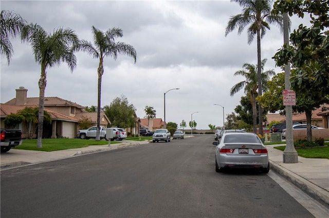 1284 William Mcgrath St, Colton, CA 92324 - view of asphalt road with sidewalks, curbs, street lighting, and a residential view
