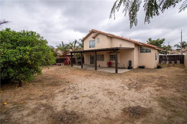 1284 William Mcgrath St, Colton, CA 92324 - back of property with a fenced backyard, stucco siding, and a patio