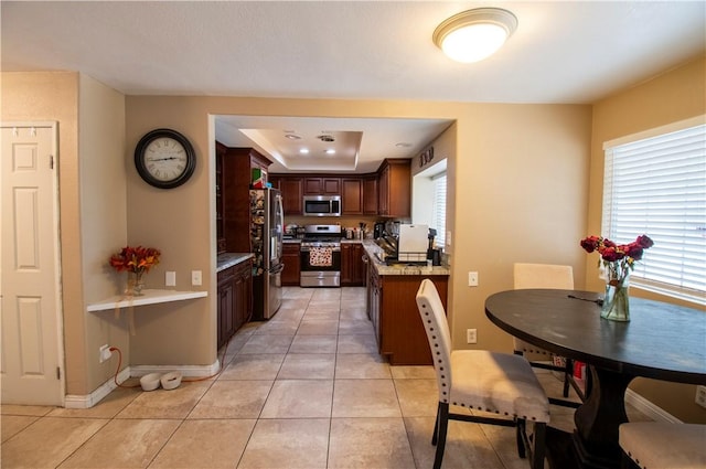 1284 William Mcgrath St, Colton, CA 92324 - kitchen with stainless steel appliances, light countertops, light tile patterned flooring, baseboards, and dark brown cabinets