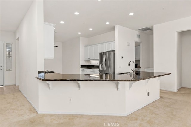 kitchen featuring stainless steel fridge with ice dispenser, recessed lighting, light colored carpet, and a sink