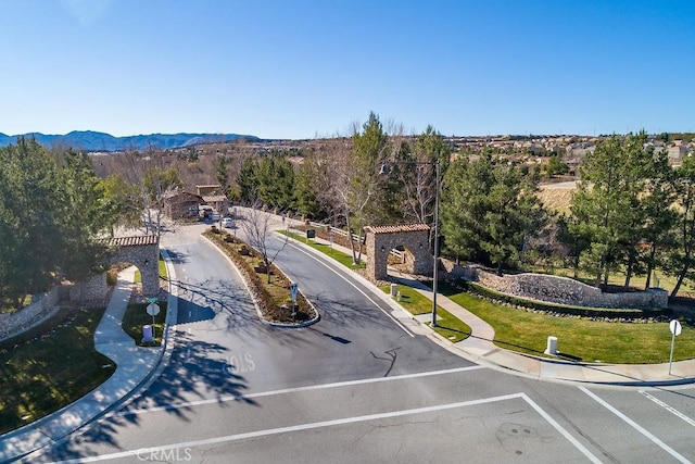 exterior space with a mountain view, sidewalks, curbs, and traffic signs