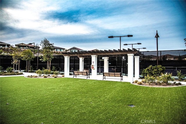 view of home's community with a pergola and a yard