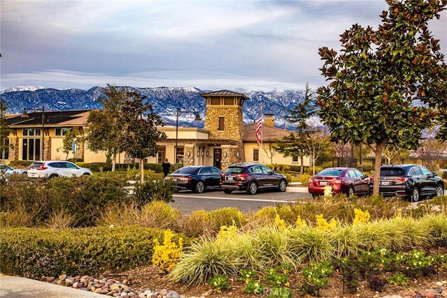 view of building exterior featuring uncovered parking and a mountain view