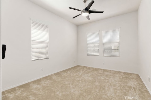 spare room with carpet flooring, baseboards, and a ceiling fan