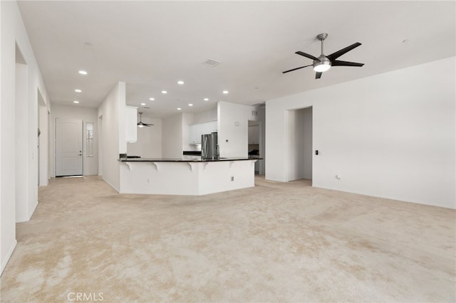 unfurnished living room featuring recessed lighting, light colored carpet, and a ceiling fan