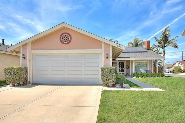 single story home featuring a front lawn, solar panels, driveway, a chimney, and an attached garage