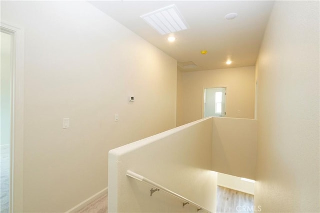 hallway with baseboards, an upstairs landing, visible vents, and recessed lighting