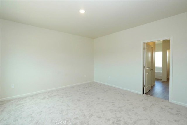 empty room featuring baseboards, carpet floors, and recessed lighting