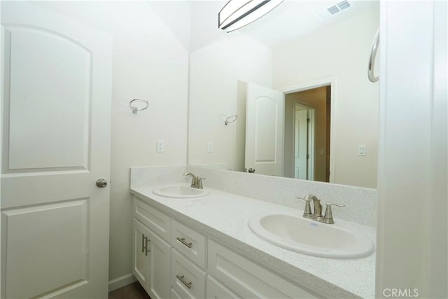 bathroom featuring double vanity, visible vents, and a sink